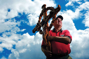 USA RV Park owner John Moore shoulders a cross he will carry for many a mile for military veterans. © 2011 Gallup Independent / Adron Gardner 